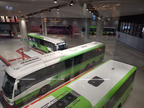 Die Buse fahren in der Tiefgarage ab. Wir haben zwei Plätze im Doppeldecker, oben  direkt an der Frontscheibe.