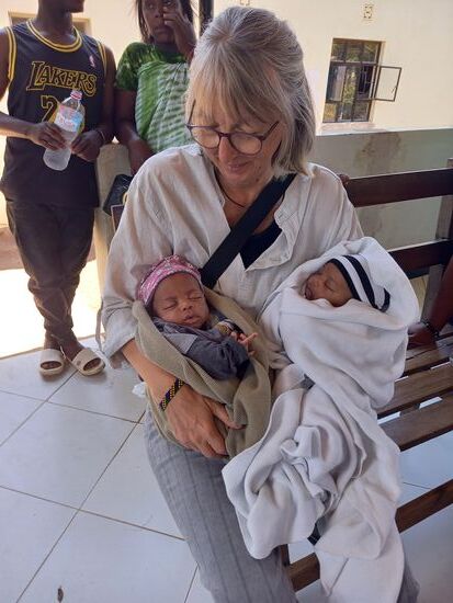 Ich sitze gemeinsam mit vielen Einheimischen auf einer wackligen Holzbank.