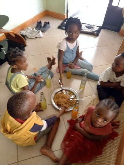 Ein paar Kinder aus der Nachbarschaft bekommen Pilau (Reis mit etwas Fleisch). Ich habe noch für jeden eine Soda besorgt.