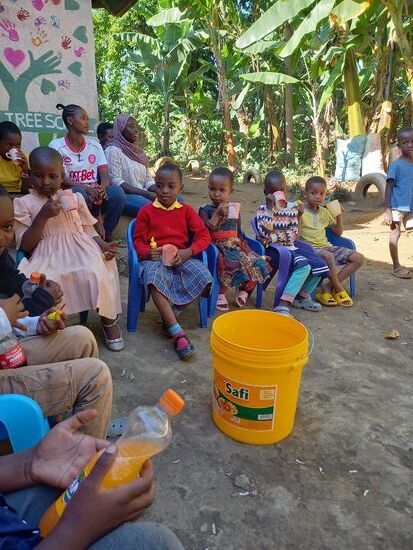 Es sind noch einige Kinder aus der Nachbarschaft gekommen und so wird die Soda geteilt und jedes Kind bekommt einen Lolly.