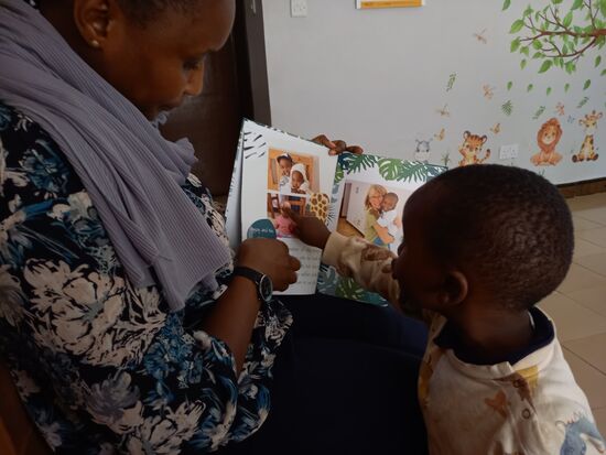 Ich habe Nuruana ein Fotobuch über das Baby Haus mitgebracht.