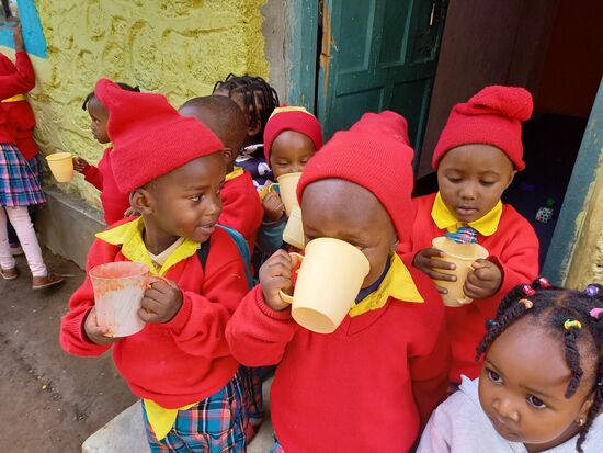 In einer kurzen Pause gibt es für jedes Kind eine Tasse Porridge.
