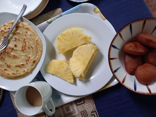 Zum Frühstück bekomme ich eine Art Eierkuchen, Mandasi und mega leckere Ananas.