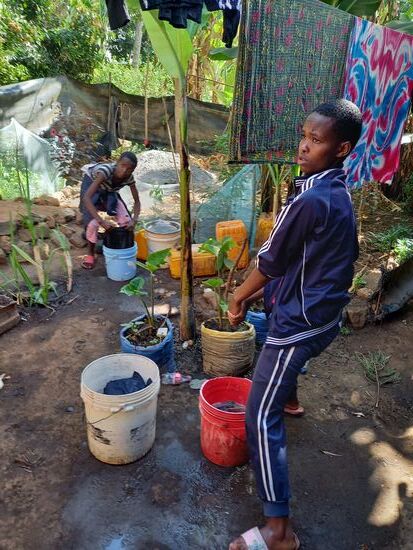 Draußen waschen die älteren Kinder die Wäsche.