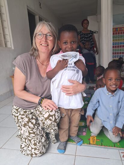 Die Kinder sind außer sich vor Freude über die mitgebrachten T-Shirts,  Hemden und Hosen.