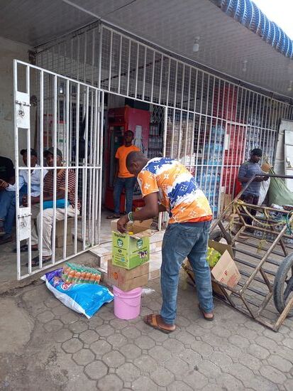 Hier habe ich mich mit Wasser versorgt. Sechs mal 1,5l kosten 5000Tzs. Das sind ca. 1,90€. Der Mann liefert gerade neue Ware an. Das Leiferfahrzeug ist der Handkarren.