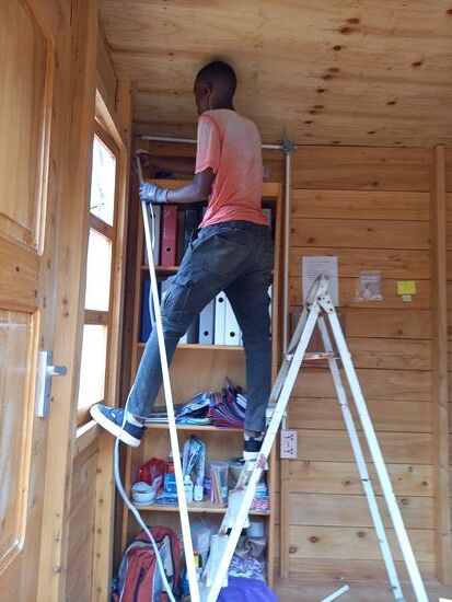 Matthias schaut dem Fundi etwas auf die Finger und Nuruana freut sich darauf endlich Strom im Büro zu haben.