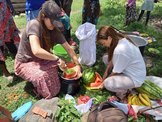 Cathrin und Donna schneiden die Melonen in Stücke.