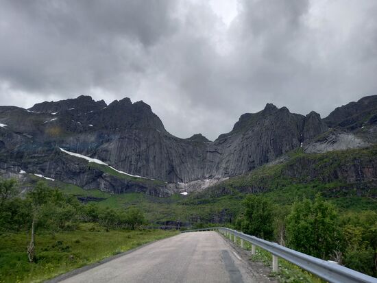 Der Weg führt an steil aufragende, schroffe, graue Berge mit spärlichen Bewuchs vorbei.