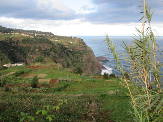 Unser Ziel - Sao Jorge. An dem kleinen ins Meer hinaus ragenden Fels ist der Bootsanleger. Im Ort der Leuchtturm.