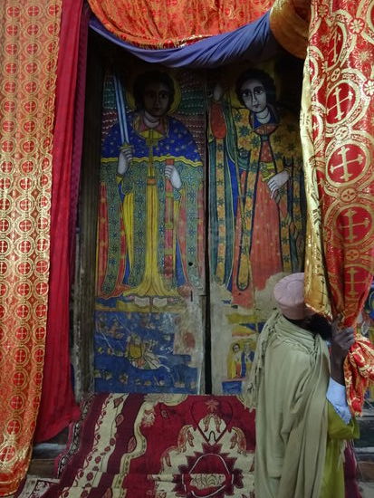 Die vielen Gemälde sind durch die Vorhänge geschützt. Ein Prister schiebt sie beiseite um den Blick darauf freizugeben.