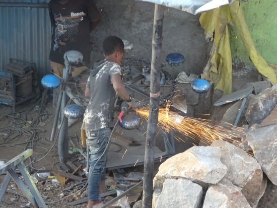 Ebenfalls direkt an der Straße ist diese Schlosserei. Der Junge arbeitet ohne jegliche Schutzkleidung.