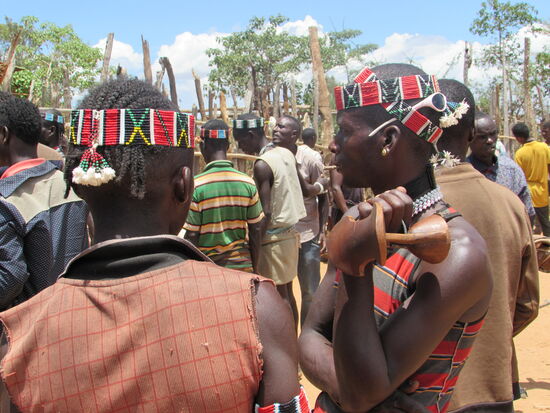 Wunderschöne Stirnbänder. Der rechte Mann hat seinen Sitzhocker dabei.
