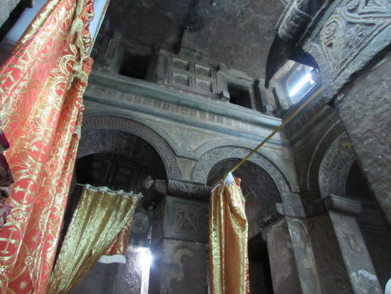 Ansonsten schmücken wunderschöne bunte Tücher und kirchliche Bilder das Innere.