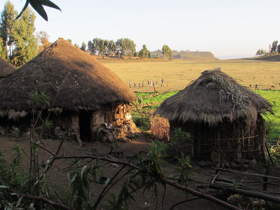 Im Hintergrund sieht man die Kinder Fußball spielen.  Als Ball dient eine rundes Etwas aus Stoff mit Stroh gefüllt.