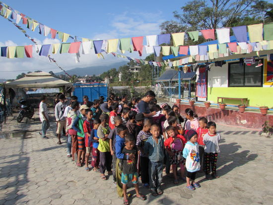Die Kinder stehen wieder brav in Reihen und Tsering notiert den Wunsch der Farbe für die Jacken.