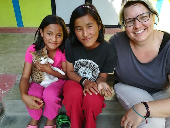 Während die ersten abreisen, vertreiben sich die anderen die Zeit. Die Katze hat es gut, sie wird von Bipana beschmust.