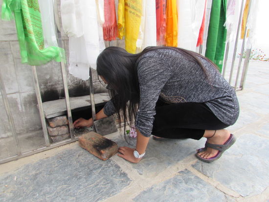 Bin entzündet eine kleine Kerze.