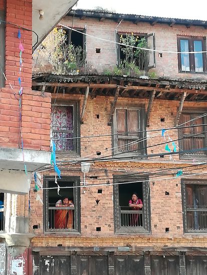 Dort oben wird gefeiert. Wir sehen viele Frauen schön zurecht gemacht in traditioneller Kleidung.