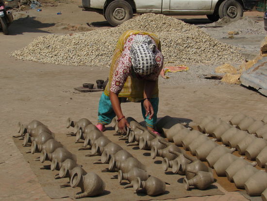 Sie dreht die Gefäße damit sie gleichmäßig trocknen.