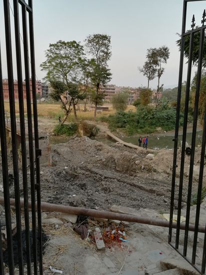 Da die Brücke zerstört ist, wurden dicke Bohlen über den Fluß gelegt. Auch hier endlos Müll 