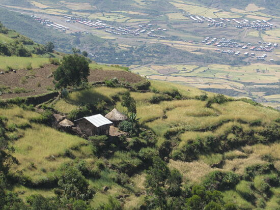 Steil bergauf geht es auf holpriger Piste weiter. Unten im Tal sind die neuen Häuser zu sehen. Hier oben leben die Menschen in ihren traditionellen Tukuls.