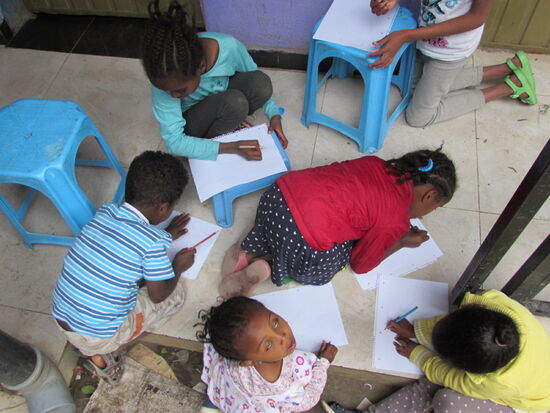 Während wir noch Fotos von dem Haus gemacht haben, malen die Kinder schon eifrig 
Da es nur einen winzigen Tisch gibt, malen viele einfach am Boden.