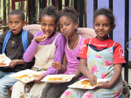 Tesfahun, Workay, Mahder und eine Freundin freuen sich auf das Essen. Es gibt Linsen, Kartoffeln und selbstgebackenes Brot.
