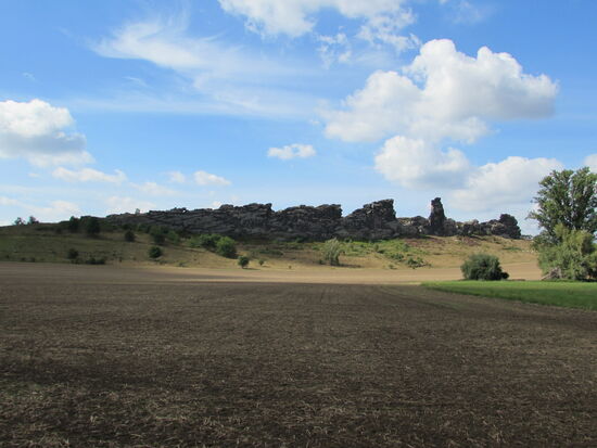 Auf einen Feldweg geht es aus dem Ort hinaus und die Felsen der Mauer ziehen unseren Blick an.