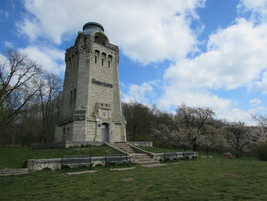 Nach einem kurzen Stück bergauf sind wir auch schon angekommen. Der Turm ragt über blühende Bäume und Büsche hinaus.