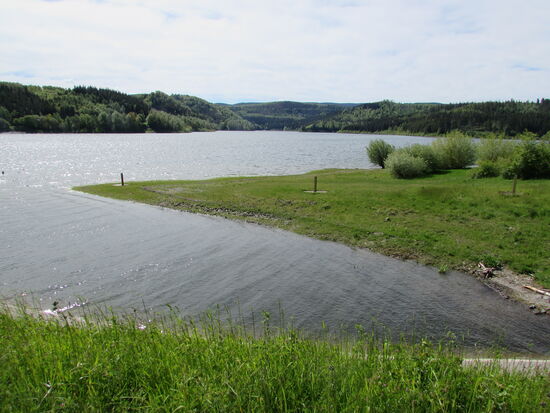 Nur wenige Gehminuten vom Parkplatz haben wir einen erster Blick von der Staumauer auf den See.