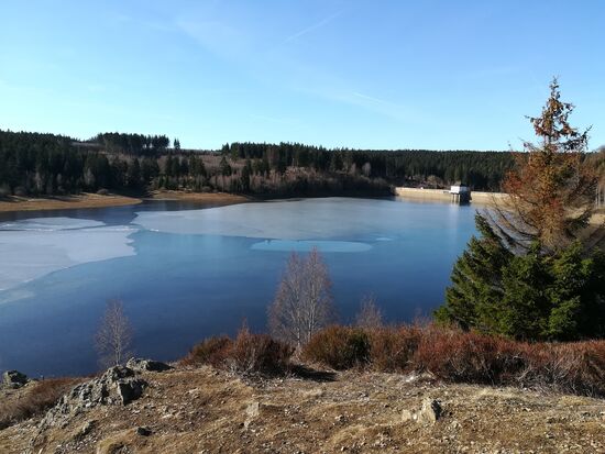 Von der anderen Seite der Talsperre sieht man die Staumauer. Hier lädt eine Bank zum Picknick ein.