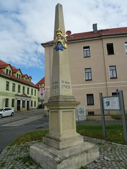 Gleich am Ortseingang treffen wir auf die Postmeilen- Distanzsäule.