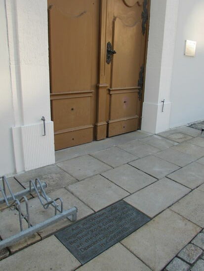 Die Eingangstür - vor der Tür eine Platte die an die Demos vor der Wende erinnert.