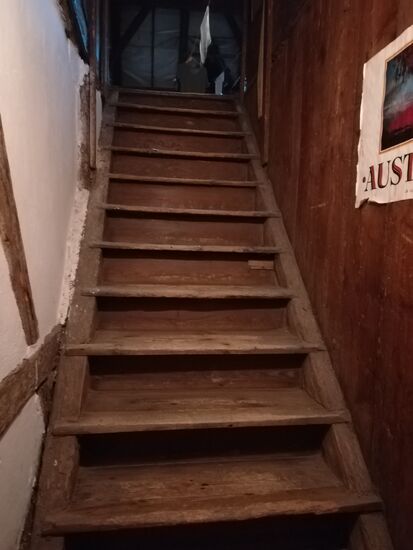 Eine steile Holzstiege führt nach oben auf den Dachboden.
