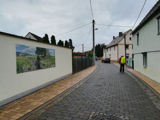 In Zweimen kommen wir an einem Gemälde vorbei, das einen Pilger aus vergangenen Zeiten zeigt.