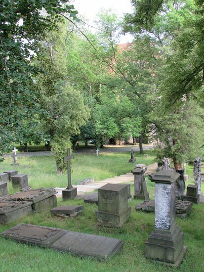 Der Friedhof neben der Nikolaikirche. Die Kirche selbst versteckt sich unter mächtigen Linden.