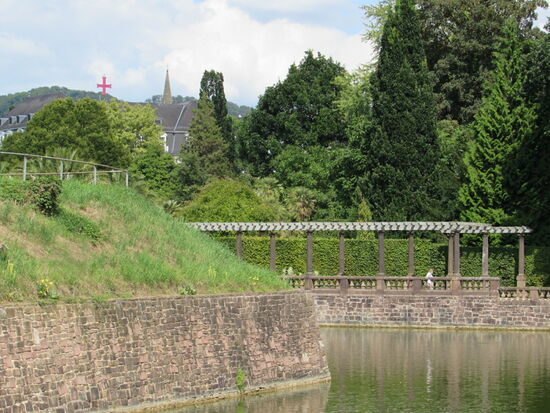 In der Ferne das rote Kreuz der Pyrmonter Mineralwasser. Denn dieser Ort ist auch für seine Quellen bekannt, die schon vor 2000 Jahren in dieser Region entdeckt wurden.