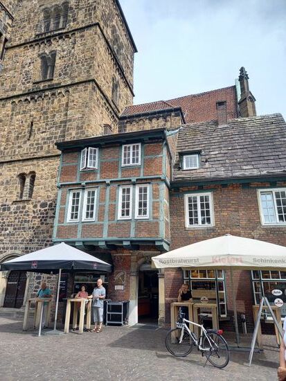 Auch gegenüber wird Bratwurst angeboten.  Das Fachwerkhaus das direkt an einer Kirche gebaut wurde,  diente einst als Unterschlupf für Witwen und Waisen.