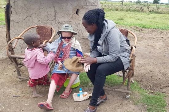 Nancy bei der Übergabe der Sonnenmilch, Brille und Creme
