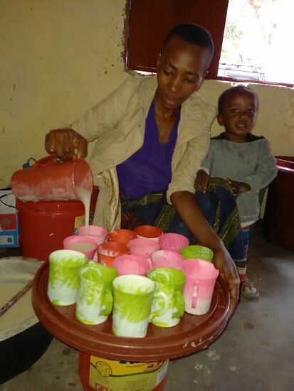 Diese junge Frau hilft ehrenamtlich und freut sich etwas von dem Porridge und Obst für sich und ihr Kind abzubekommen.