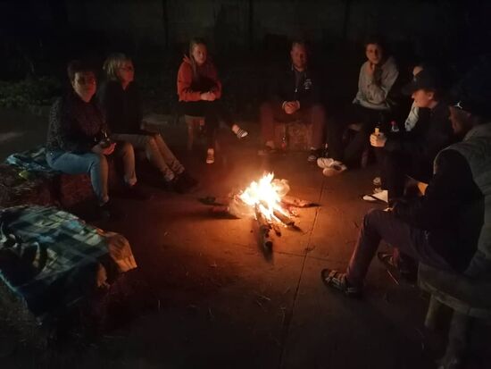 Der Tag klingt am Lagerfeuer aus - jeder der Gäste gibt ein bisschen Reiselatain zum besten 