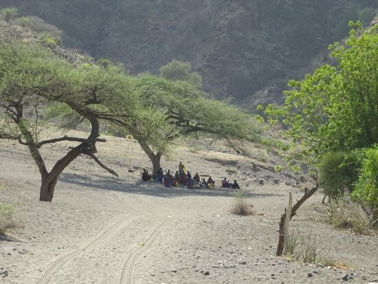Auf dem Weg zum Fluss - Massai Frauen sitzen im Schatten der Akazie.