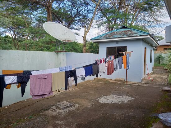 Der Wäscheplatz mit Blick auf ein kleines Gebäude,  welches die Küche beherbergt.