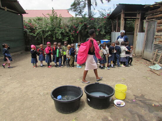 Endlich Essen und die Kinder stellen sich brav an und warten bis sie ihren Teller bekommen.
