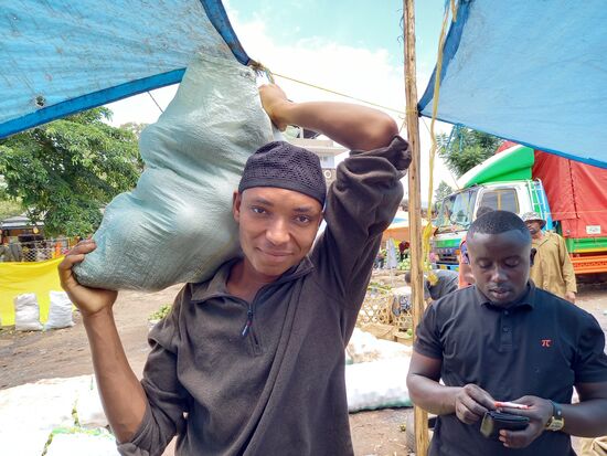 Dieser Junge Mann bringt die prall gefüllten Säcke gleich ins Fahrzeug.