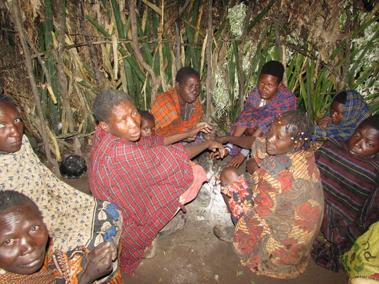 Die Frauen kauern sich an der Feuerstelle zusammen.