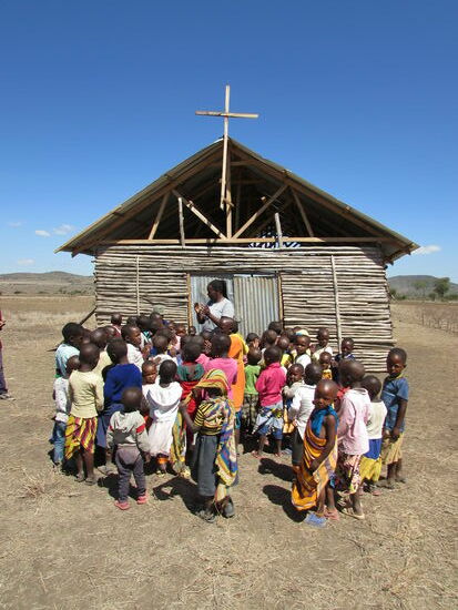 Die Kinder und Nancy singen für uns ein Begrüßungslied.