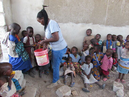 Die Mädchen und Jungen freuen sich über ein Stück Mango, Ananas und Melone.