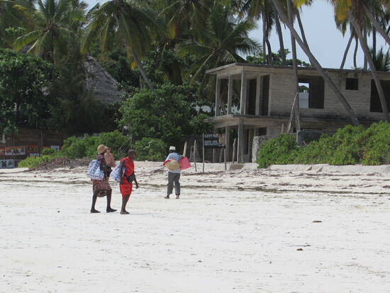 Massai spazieren den Strand auf und ab, immer auf der Suche nach Kundschaft für ihre handgefertigten Gegenstände wie Schmuck und Schnitzereien.